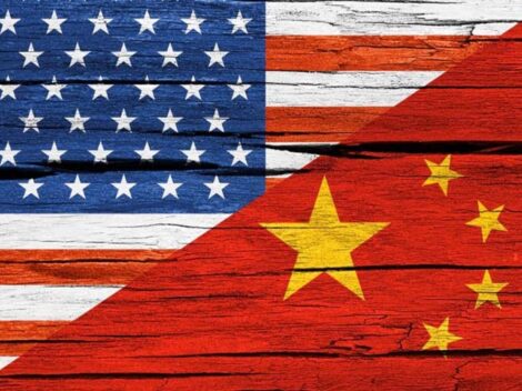 Concept image: relationship USA - China. USA and China flags diagonal portions on cracked wood [Li-Anne Dias]